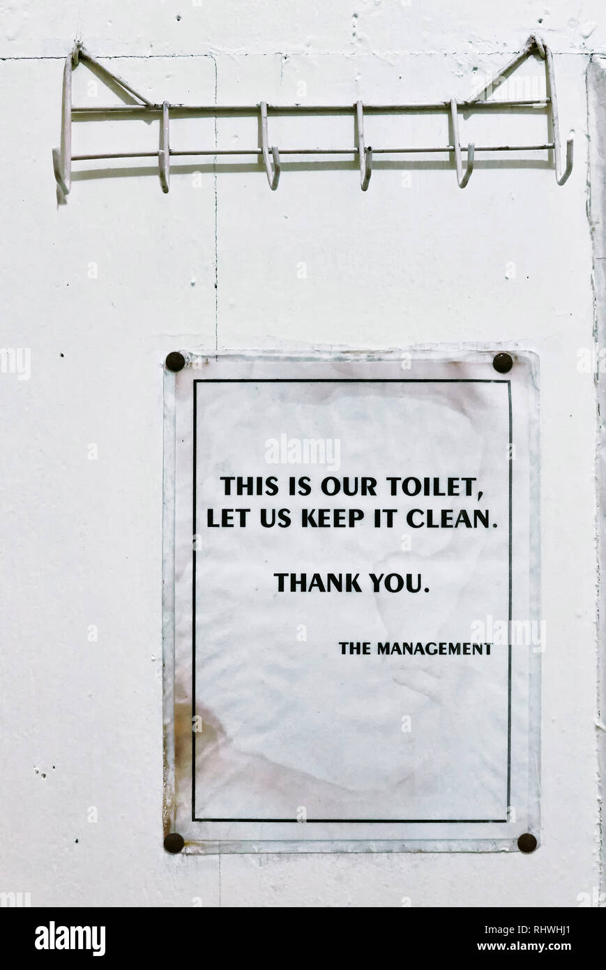Toilettes advisory signe, de garder la salle de bain propre, suspendu à un mur peint en blanc, d'un toilettes dans une maison de retraite bon marché à Palawan, Philippines Banque D'Images