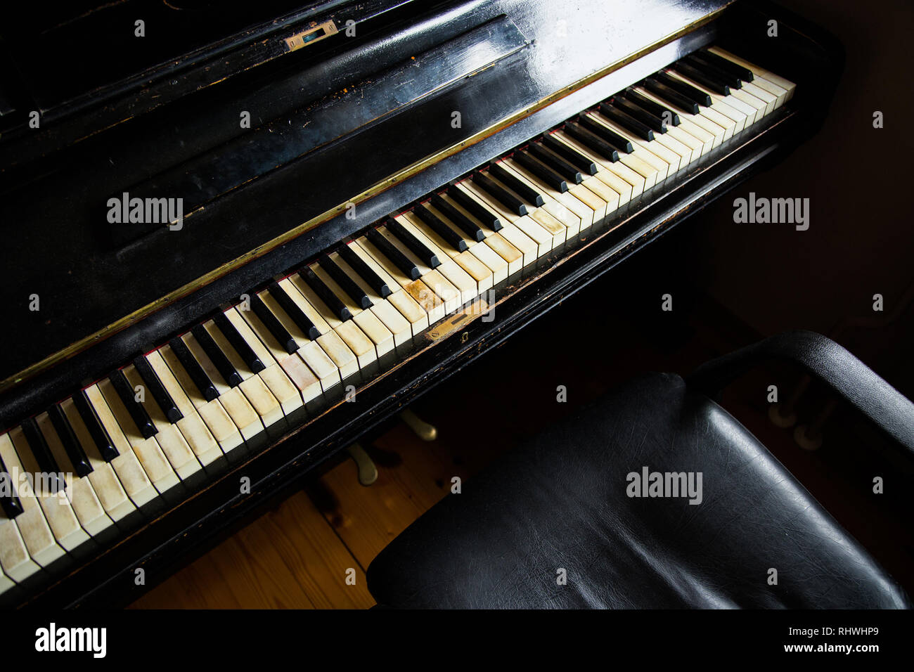Old vintage piano en bois sculpté dans une pièce sombre Banque D'Images