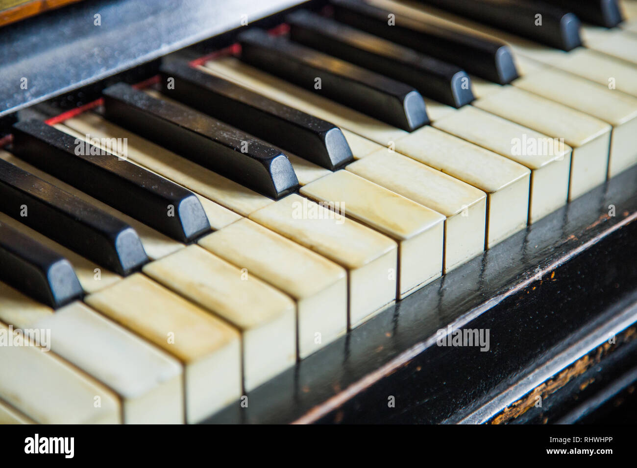 Old vintage piano en bois sculpté dans une pièce sombre, un clavier détail Banque D'Images