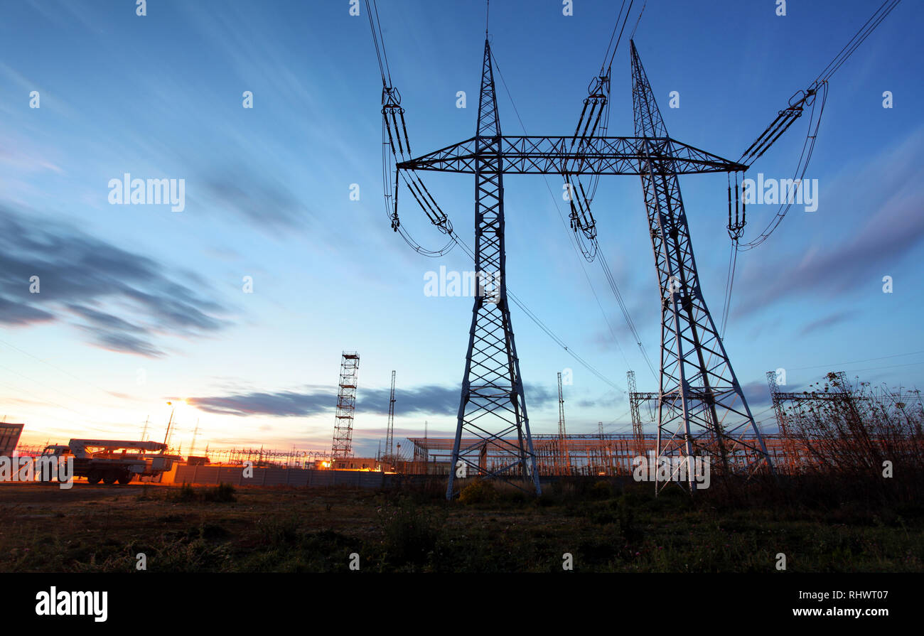 Pylône de transport d'électricité silhouetté contre le ciel bleu au crépuscule Banque D'Images