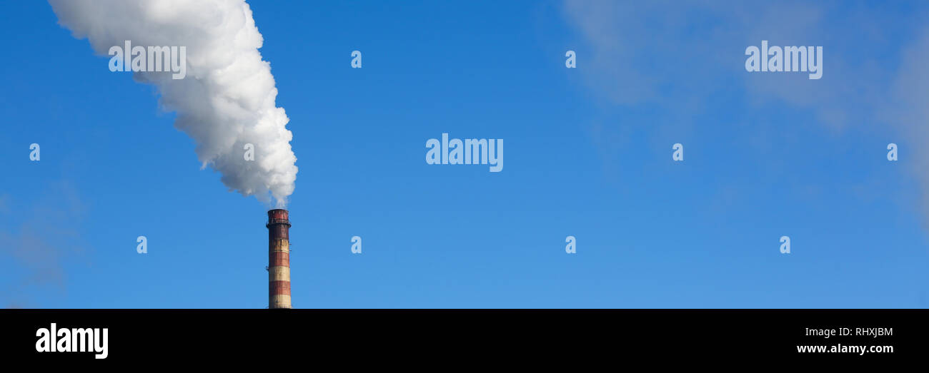 Les tuyaux de fumée blanche vient de contre le ciel bleu Banque D'Images