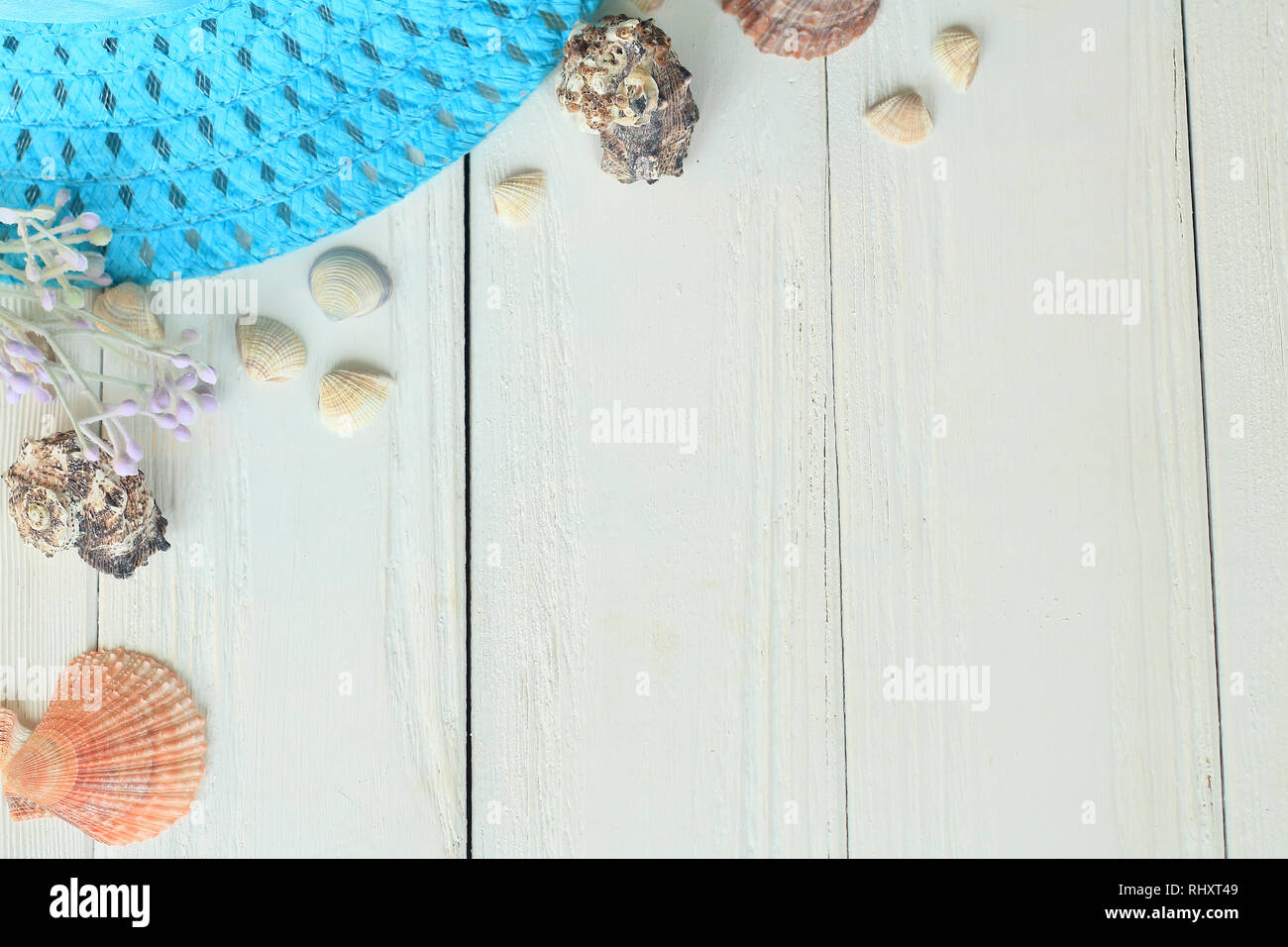 Chapeau de paille et les coquillages de la plage sur un fond de bois.photo avec place pour le texte. Banque D'Images
