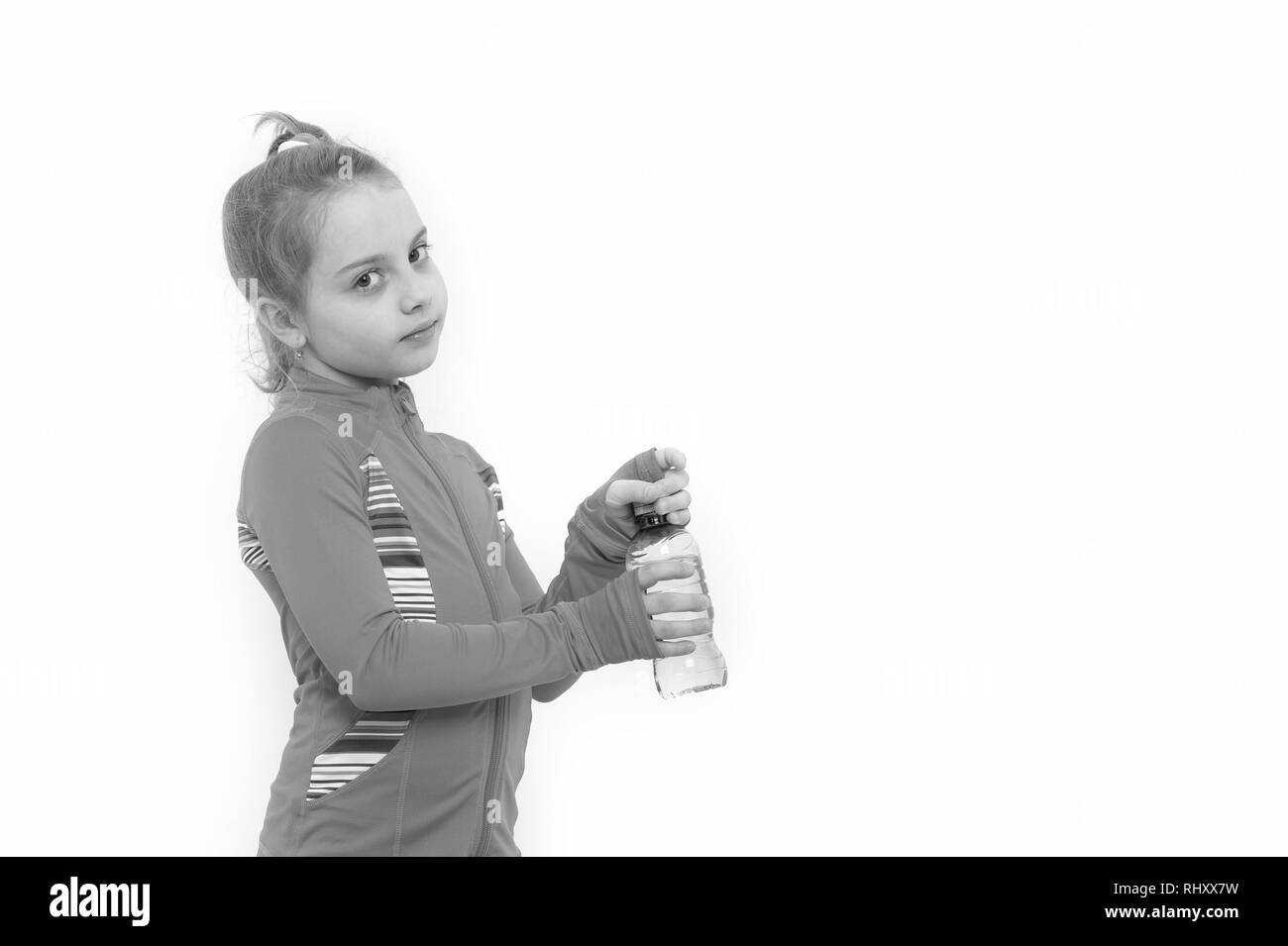 Soif de l'enfant en costume rose isolé sur blanc. Fille avec bouteille d'eau potable. La santé et de boisson saine. La déshydratation soif concept. L'équilibre liquide, hydratation copy space Banque D'Images