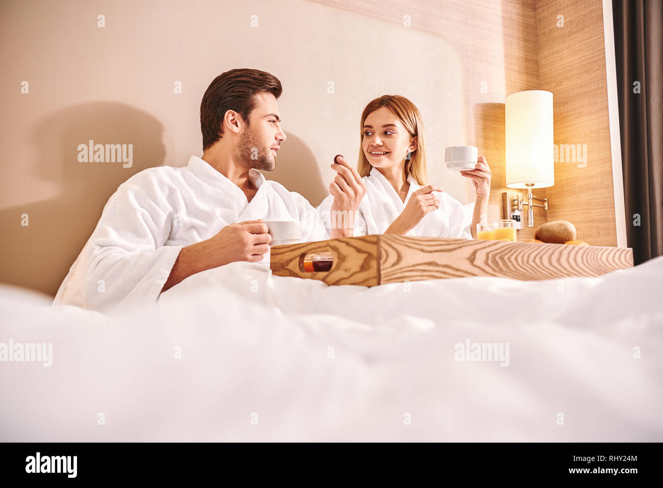 Bonbons au chocolat pour le petit déjeuner. Couple mangent dans chambre  d'hôtel lit ensemble. Histoire d'amour. Chocolat sur lit blanc Photo Stock  - Alamy