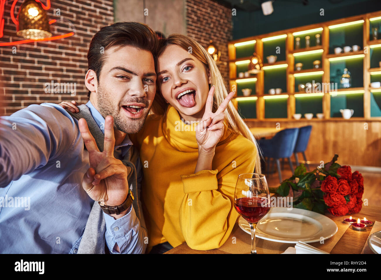 Drôle de couple photo. Young couple smiling et décisions sur photo selfies téléphone tout en ayant le dîner, close-up Banque D'Images