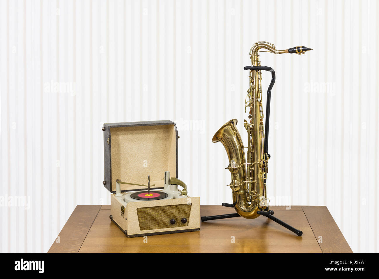 Ancien record player et saxophone sur table en bois. Banque D'Images