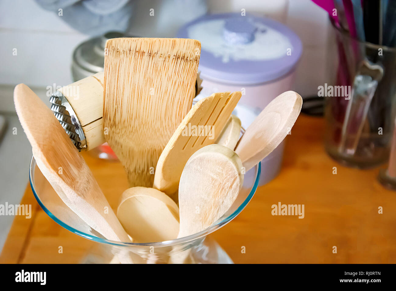 Des ustensiles de cuisine en bois dans un récipient en verre. Cuisine intérieur tourné. Concept de cuisine et décoration Banque D'Images