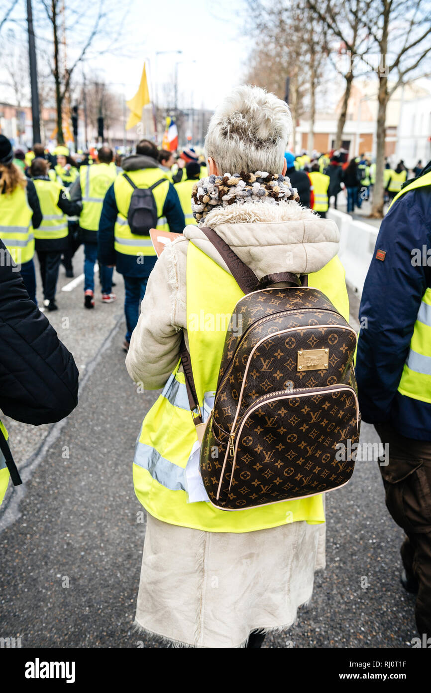 STRASBOURG, FRANCE - DEC 02, 2018 : vue arrière de femme adulte avec Louis  Vuitton sac à dos au cours de protestation de gilets jaunes Gilet jaune  manifestation les manifestations anti-gouvernementales sur