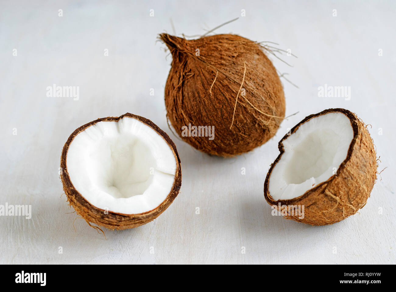 Ensemble, coco mûre et fissuré dans la moitié, assis sur fond gris et vu de l'angle élevé en close-up Banque D'Images