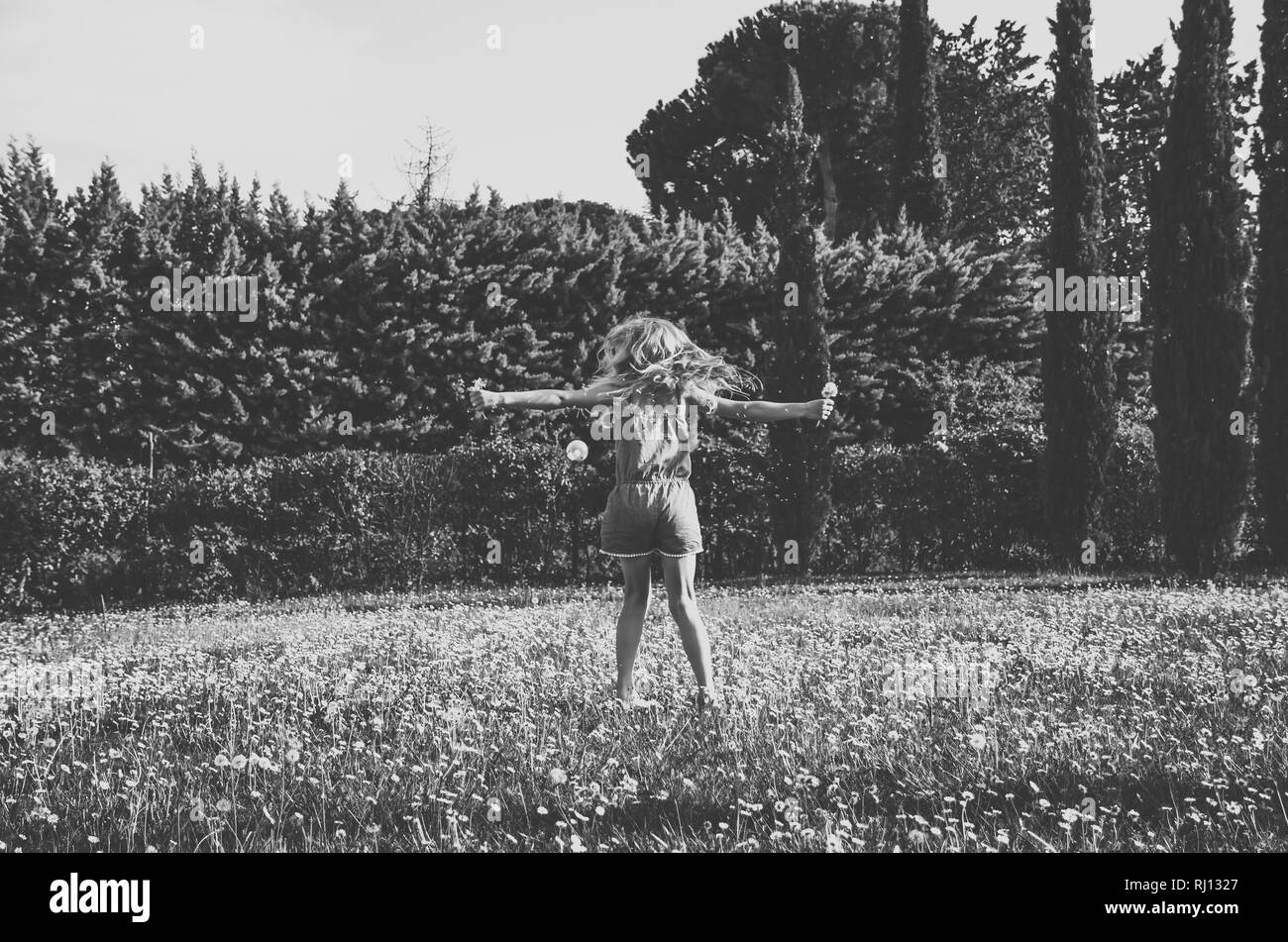 Adorable petite fille à l'extérieur en pleine prairie de marguerites dancing Banque D'Images