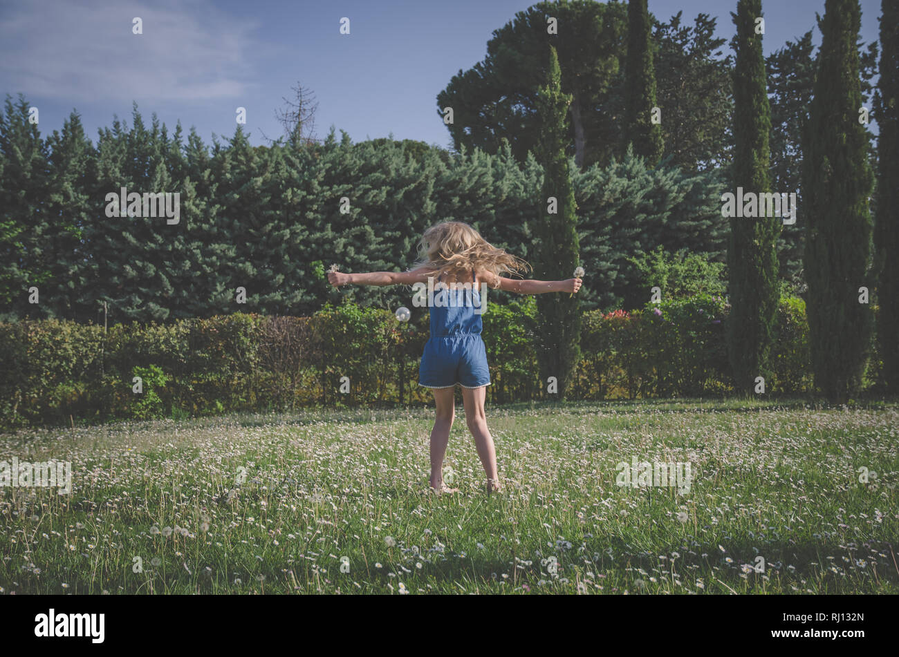 Adorable petite fille à l'extérieur en pleine prairie de marguerites Banque D'Images