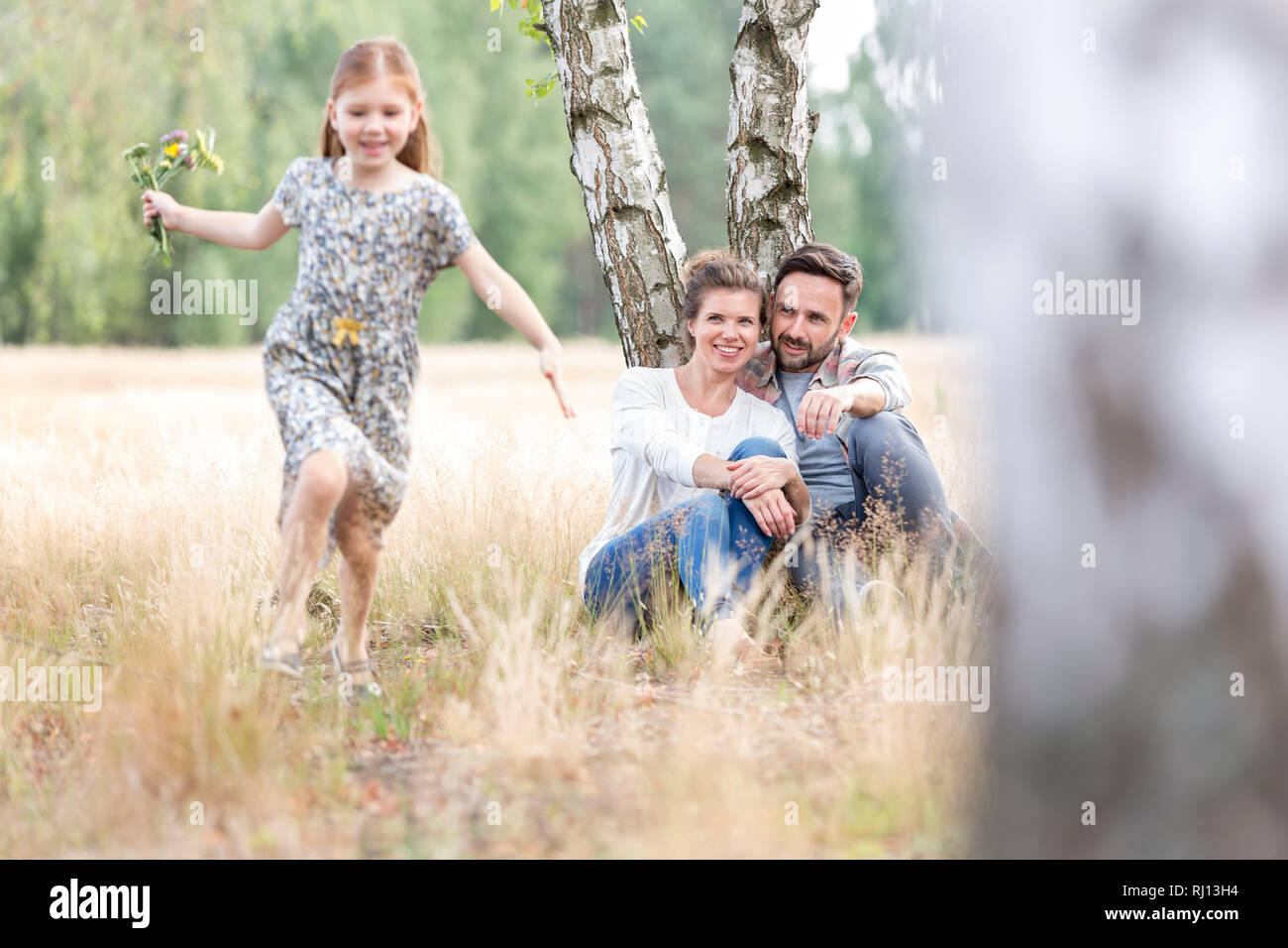 Les parents à la fille à exécution sur le champ à farmland Banque D'Images