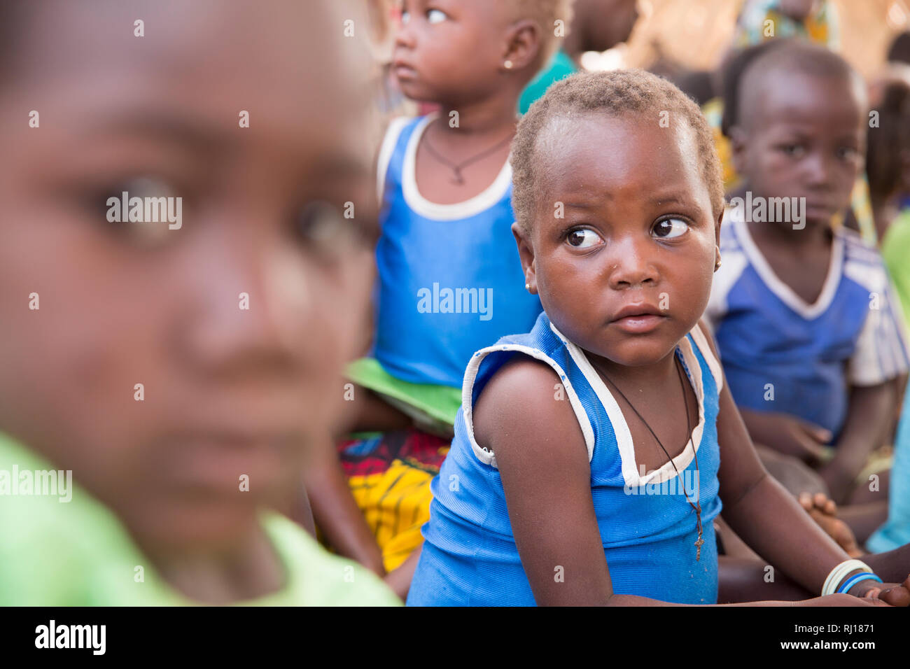 Village de samba, Province de Yako, Burkina Faso. Les enfants malnutris watch ademonstration de porridge et attendre leur servant d'être prêt. Banque D'Images