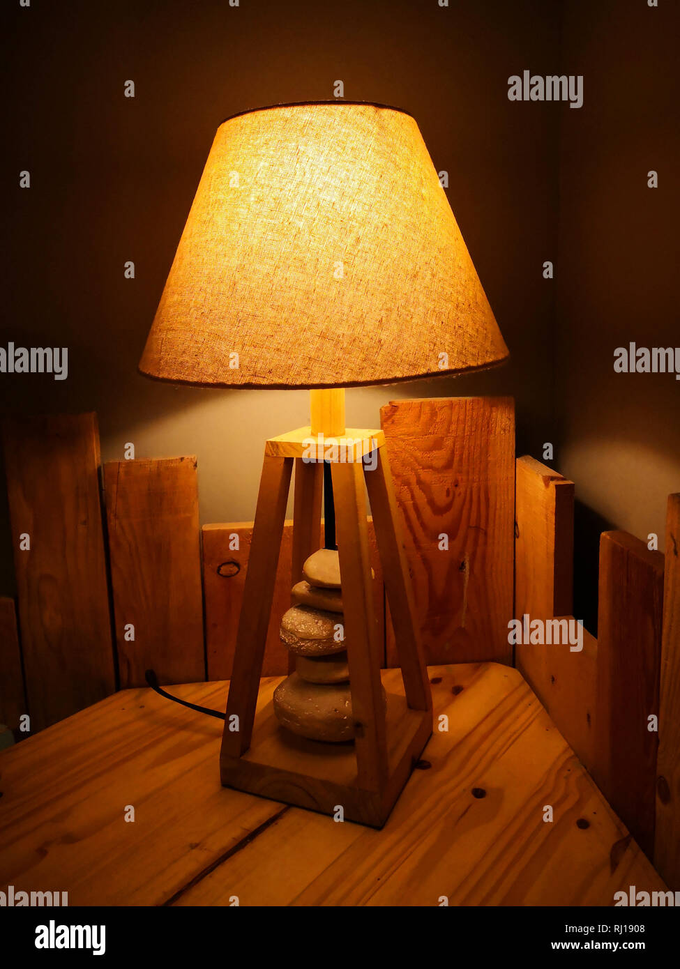 Lampe artistique jaune avec des pierres sur la table en bois Banque D'Images