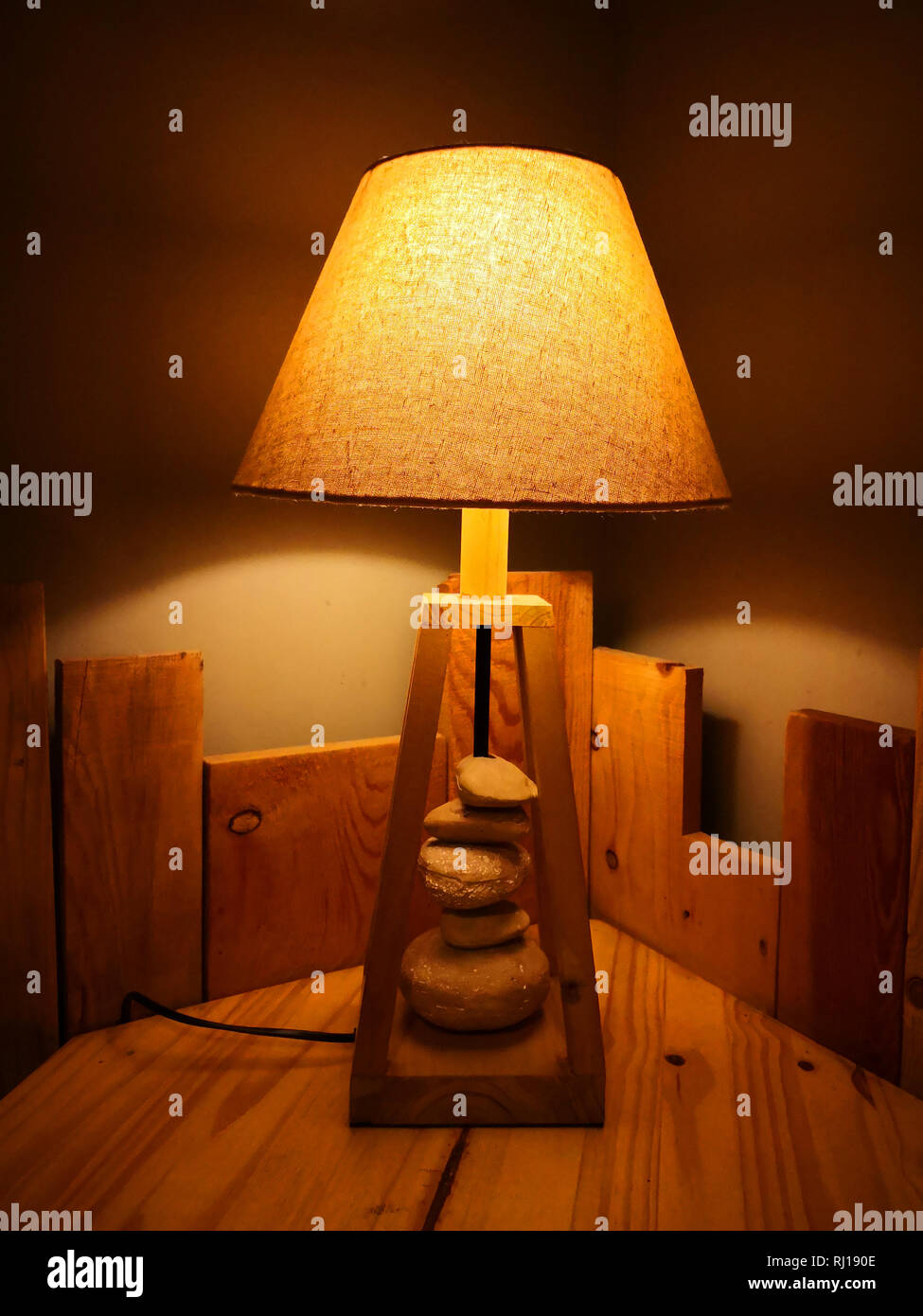 Lampe artistique jaune avec sous-sol en bois et rock sur la table Banque D'Images