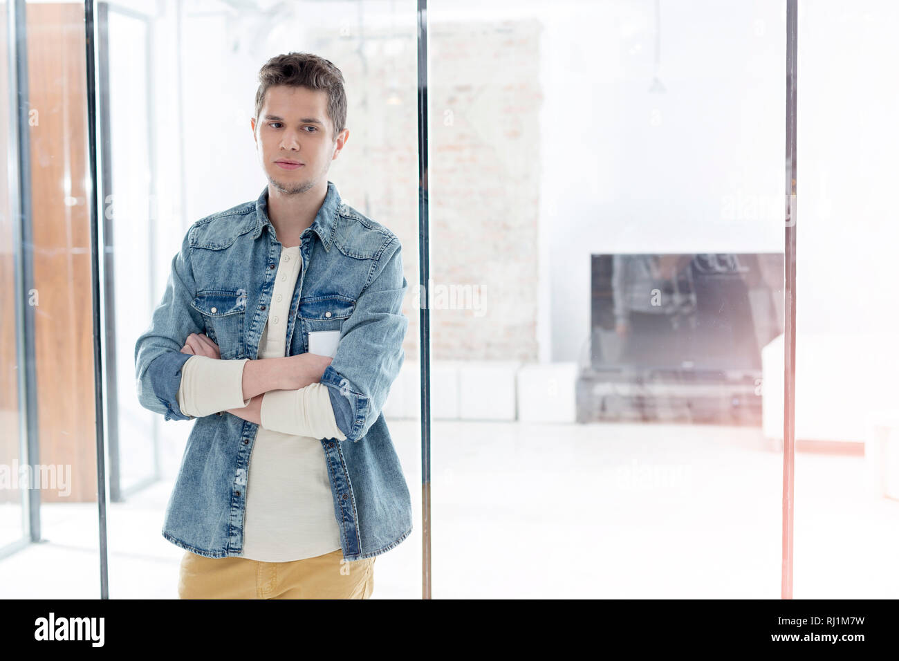 Thoughtful woman glass wall in office Banque D'Images
