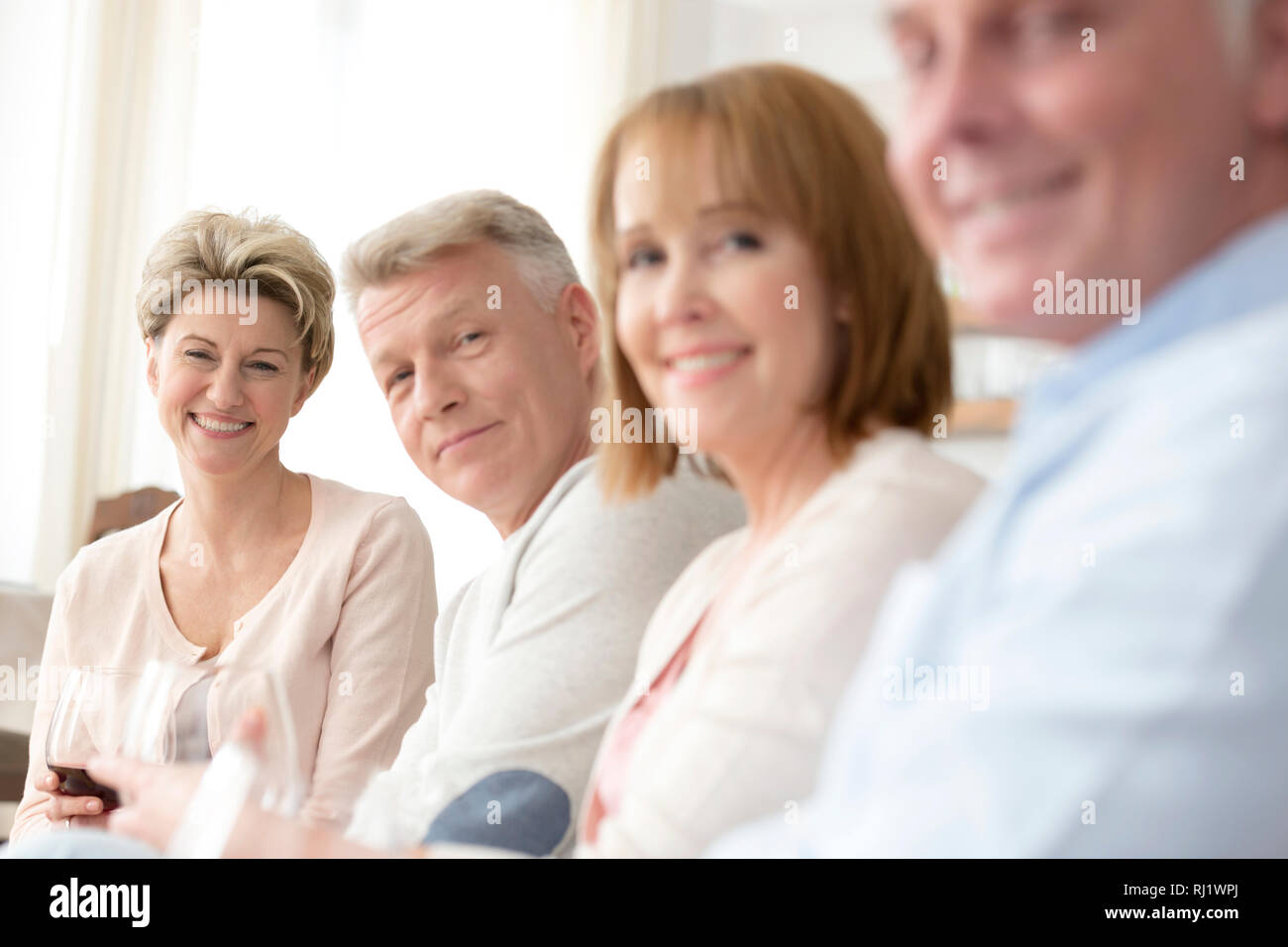 Portrait of smiling young friends sitting at home Banque D'Images