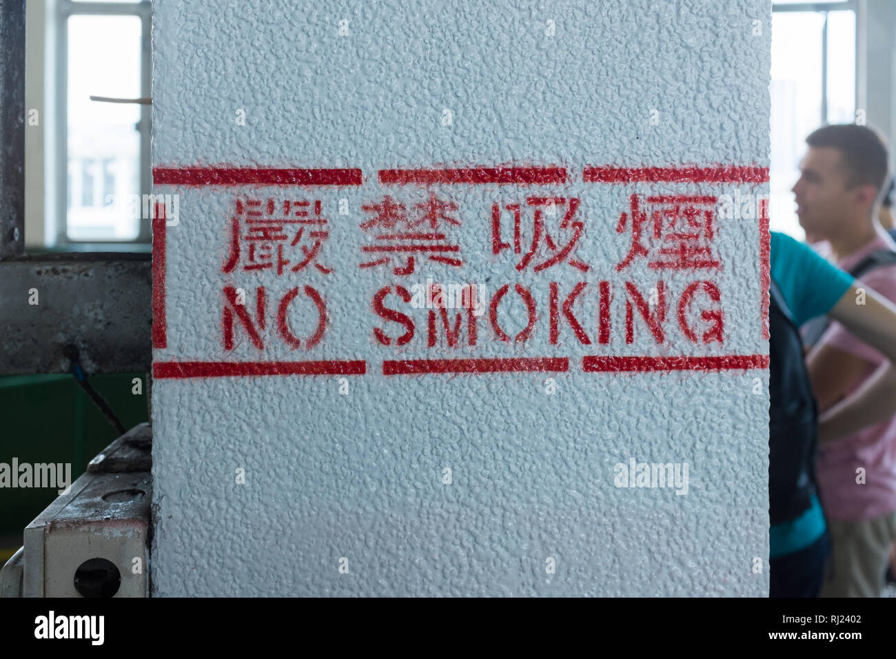 Aucun signe de fumer inscrit sur pilier blanc du Star Ferry Pier sur Tsim Sha Tsui, Hong Kong Banque D'Images