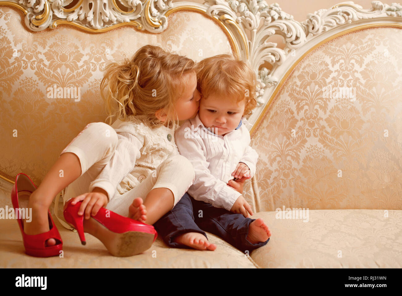 Kiss soeur frère aux cheveux blonds sur canapé classique Photo Stock - Alamy