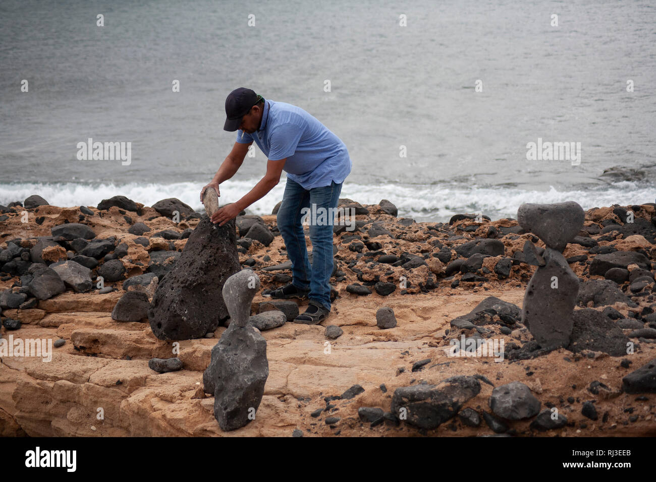 L'homme sur la plage des roches d'équilibrage. Banque D'Images