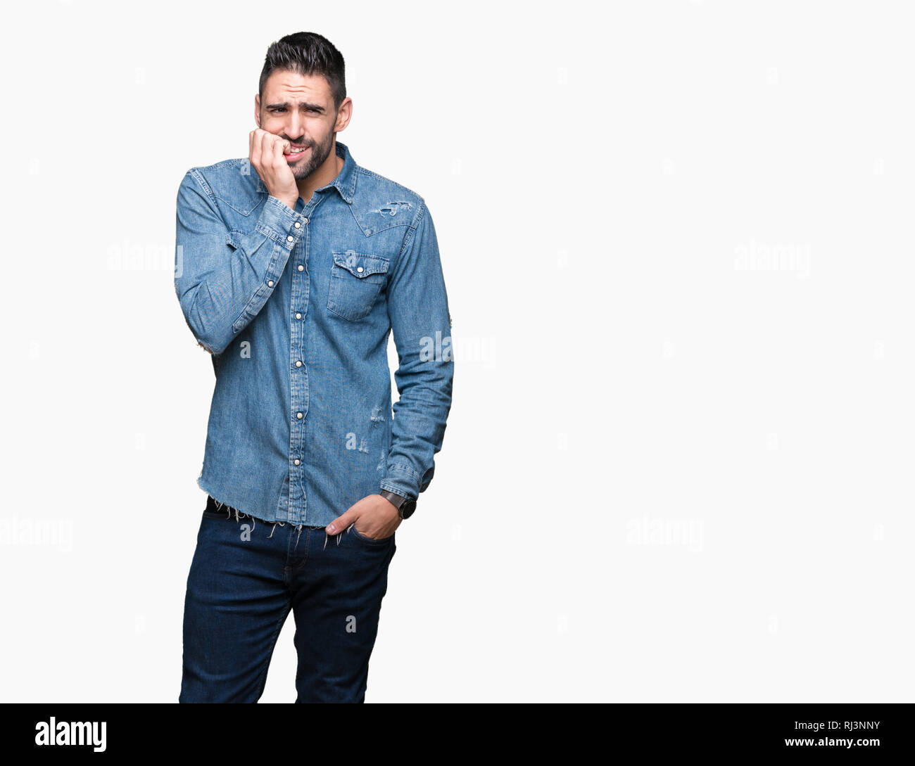 Jeune homme séduisant sur fond isolé à souligné et nerveux avec les mains sur la bouche de mordre les ongles. Problème d'anxiété. Banque D'Images