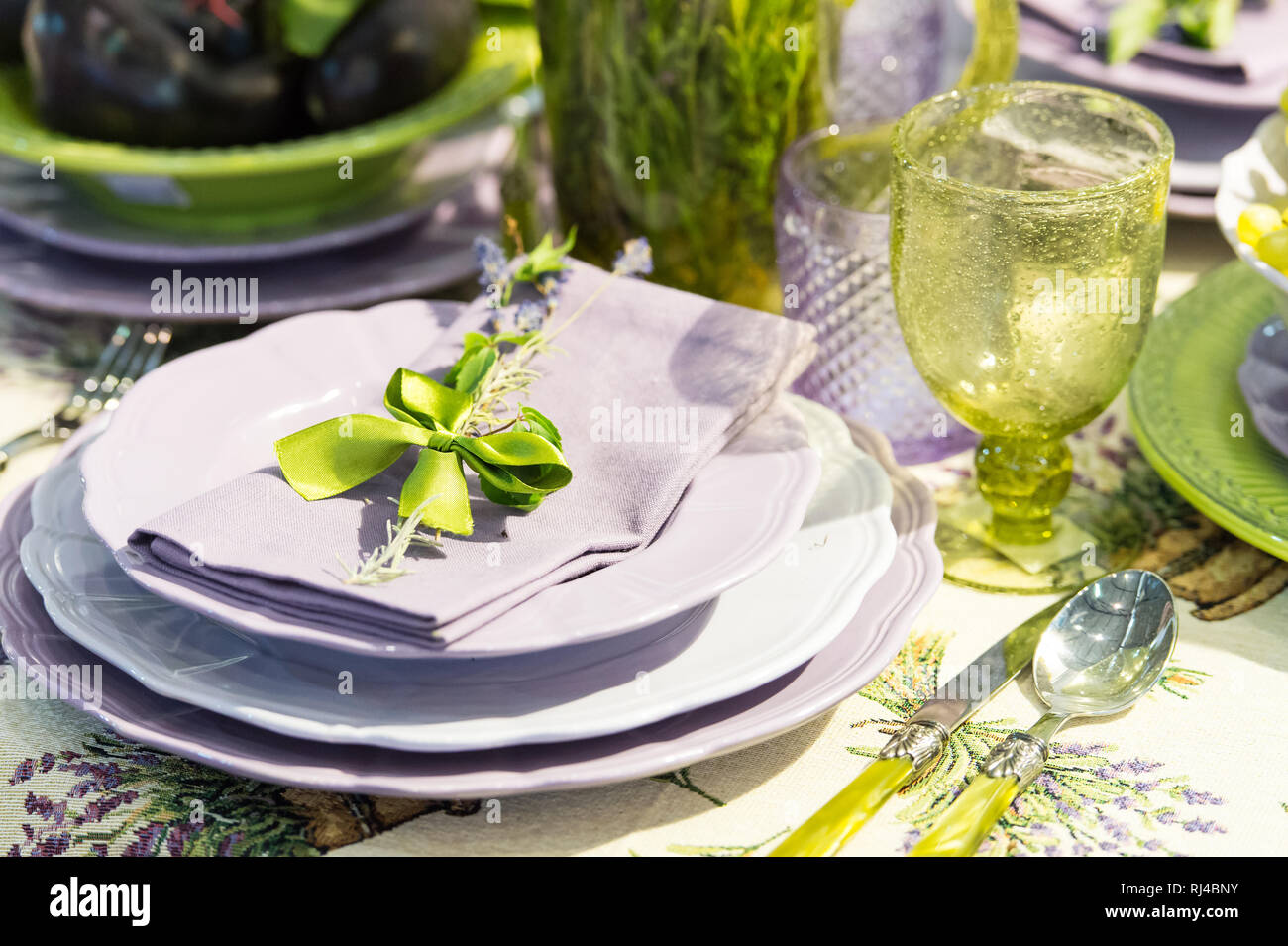 Service de table et décoration florale couleurs vert et violet avec des  fleurs en verre et cuillère plaques serviette bow-couteau avec personne  Photo Stock - Alamy