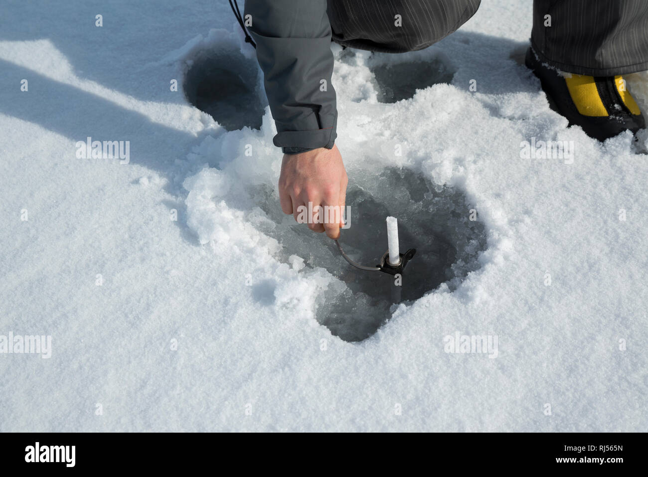 Les hommes de la glace sur un lac gelé avec broche à glace derrière la main. Selective focus Banque D'Images