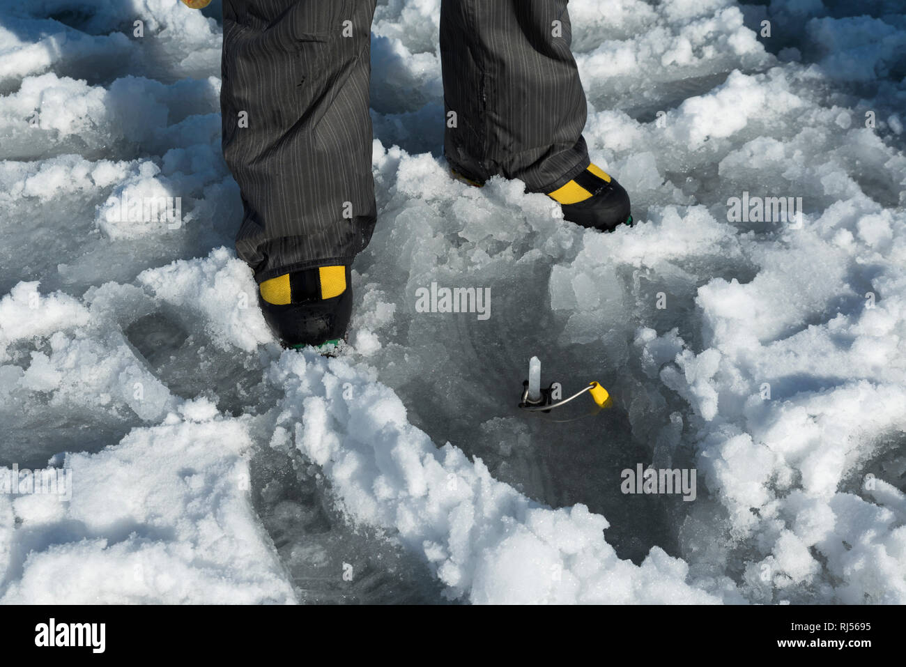 Les chaussures jaunes et jaune broche à glace percer dans un lac gelé. Selective focus Banque D'Images