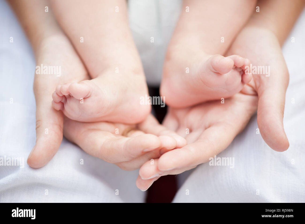 Douce mère mains serrant pieds de son enfant, la mère de l'amour, M. disponibles sur demande, Banque D'Images