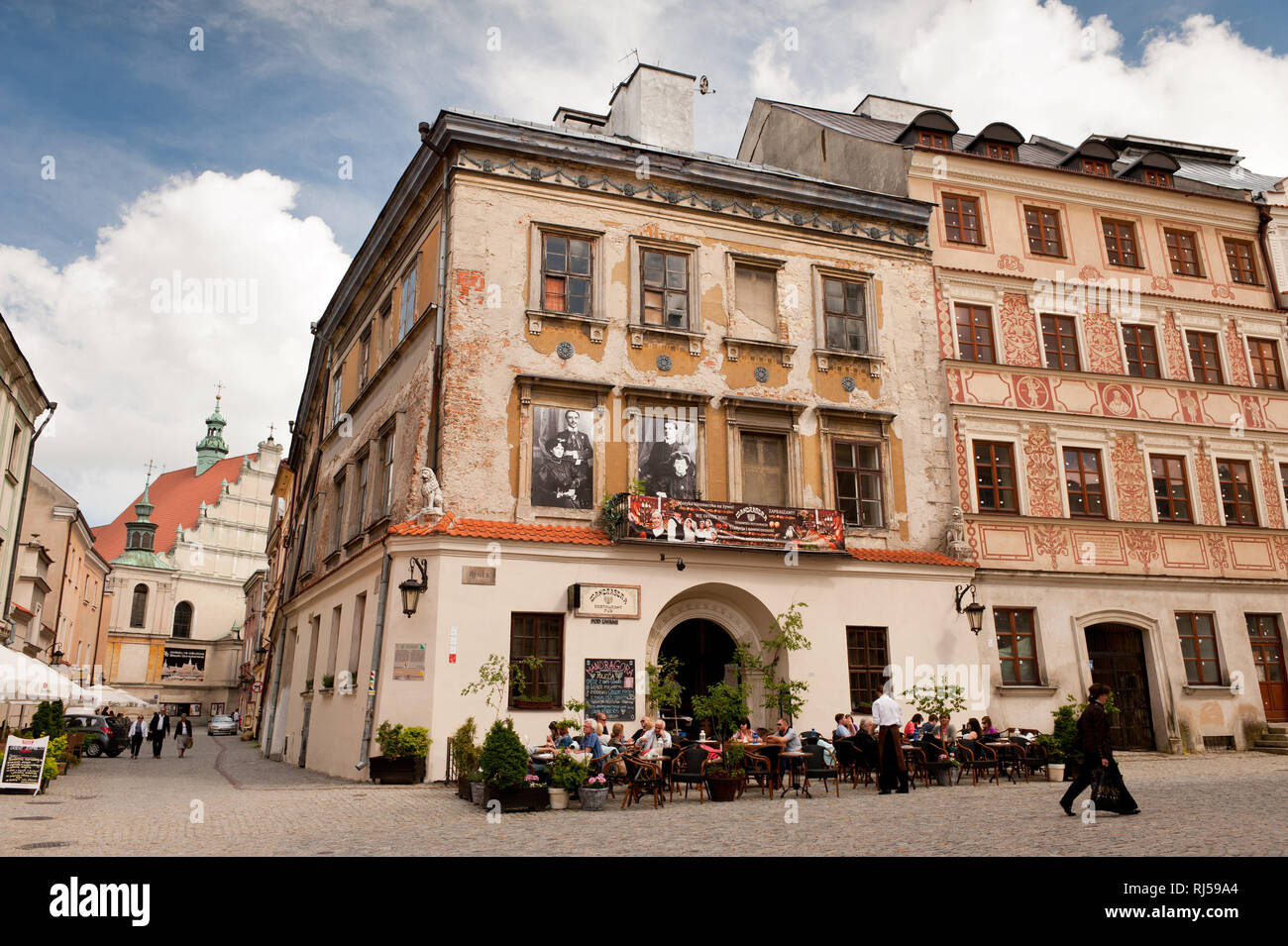 Ancien restaurant juif Mandragora délabré à Lublin, Pologne, la vieille ville, les touristes assis et de manger à l'extérieur des portes avant et des piétons circulent sur w Banque D'Images