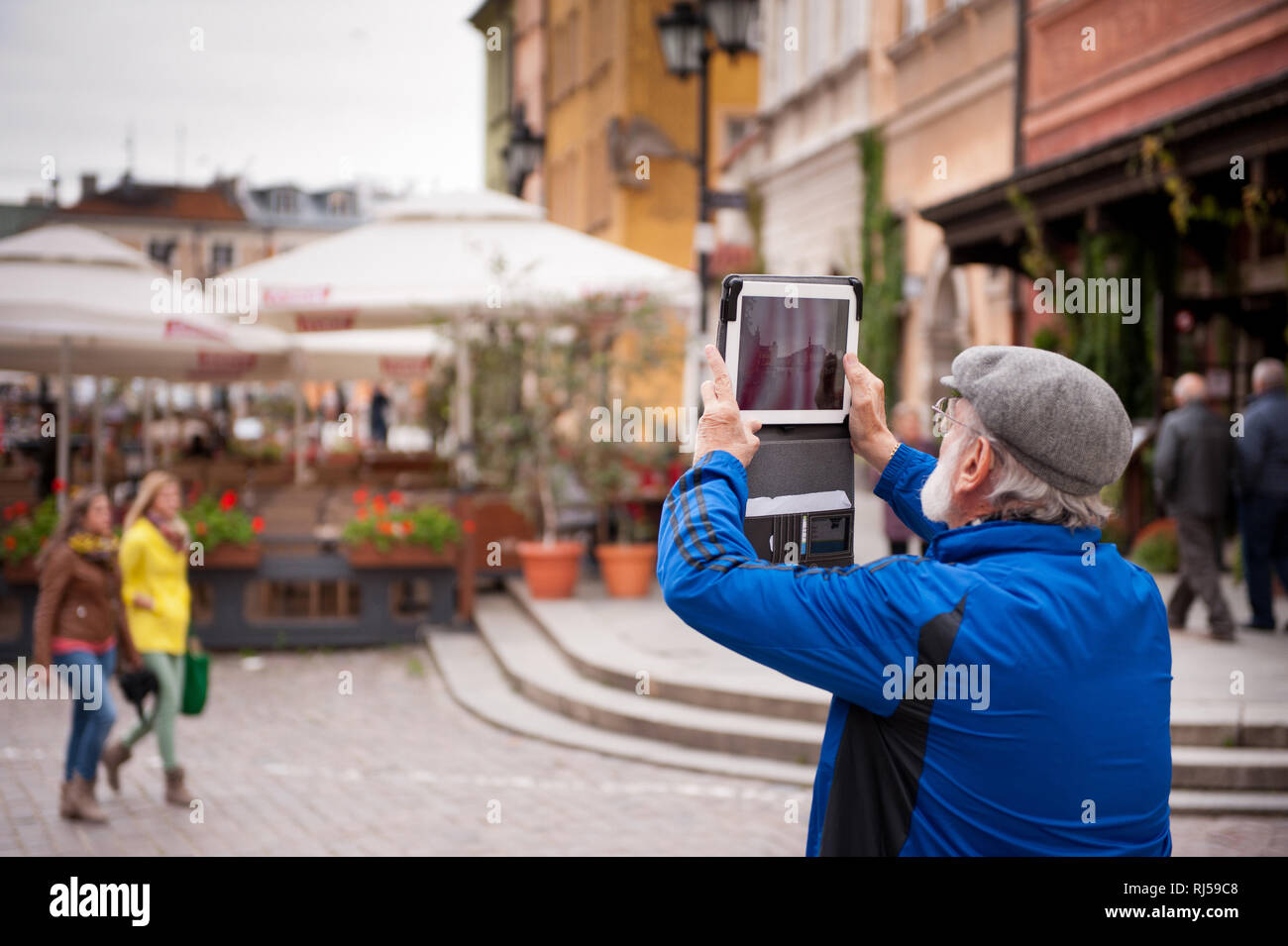 Photo prise touristiques avec l'iPad, vieux barbu en veste bleue et grise beret photo Château Royal Square plein de touristes, saison touristique en plac Banque D'Images
