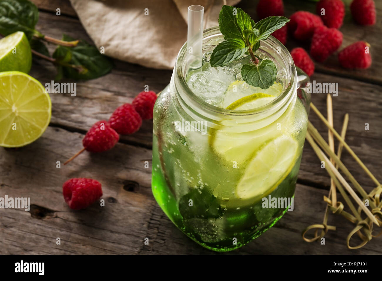 Froid limonade savoureuse boisson fraîche au citron, menthe, framboise, glace et lime en verre sur la table en bois. Libre. Banque D'Images