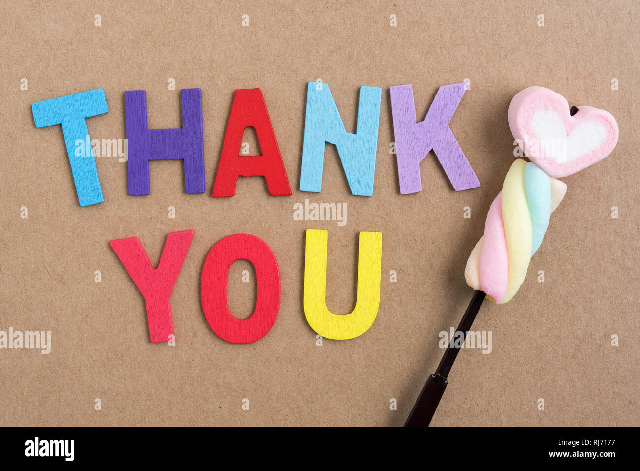 Les mots colorés merci faite avec des lettres en bois avec valentine candy  sur fond de papier brun Photo Stock - Alamy