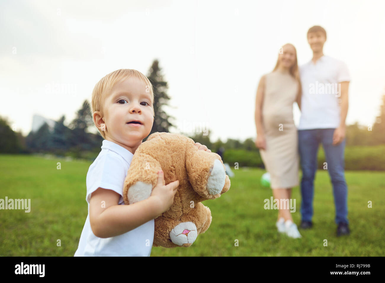 Adorable boy carrying toy en parc avec les parents Banque D'Images