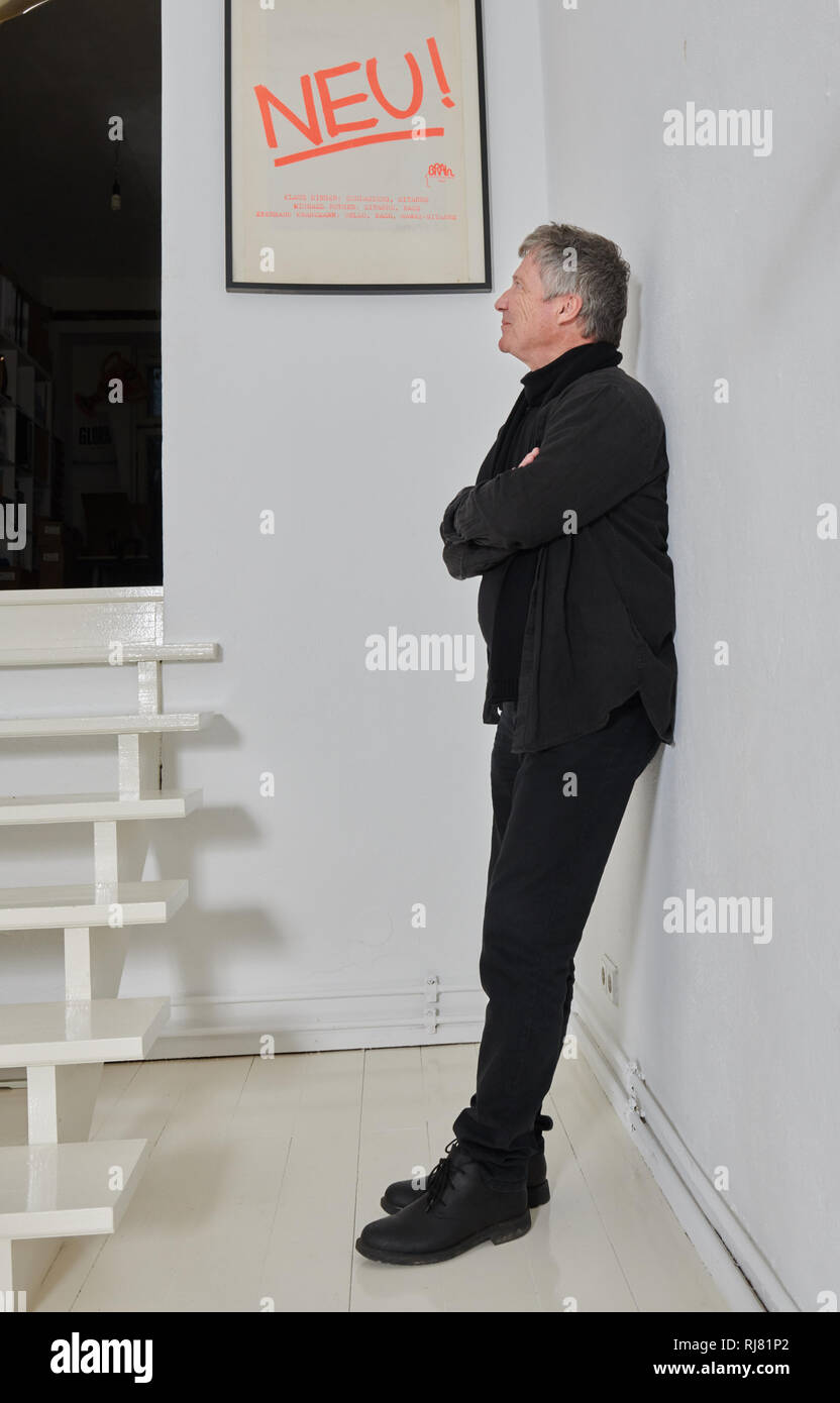 Berlin, Allemagne. 17 Jan, 2019. Le musicien Michael Rother s'appuie contre le mur de sa maison de disques Dominique Bureau et regarde l'affiche de son groupe Neu ! (1971-1975). Son nouvel album 'Solo' sera publié le 22.02.2019. Credit : Annette Riedl/dpa/Alamy Live News Banque D'Images