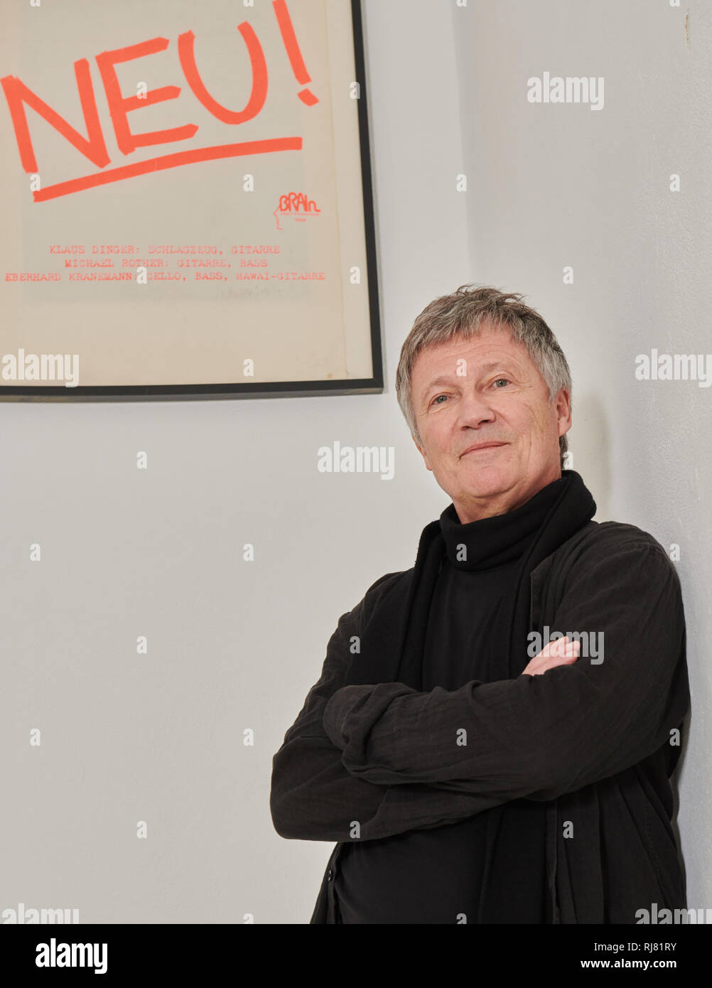 Berlin, Allemagne. 17 Jan, 2019. Le musicien Michael Rother s'appuie contre le mur de sa maison de disques Dominique Bureau et regarde l'affiche de son groupe Neu ! (1971-1975). Son nouvel album 'Solo' sera publié le 22.02.2019. Credit : Annette Riedl/dpa/Alamy Live News Banque D'Images