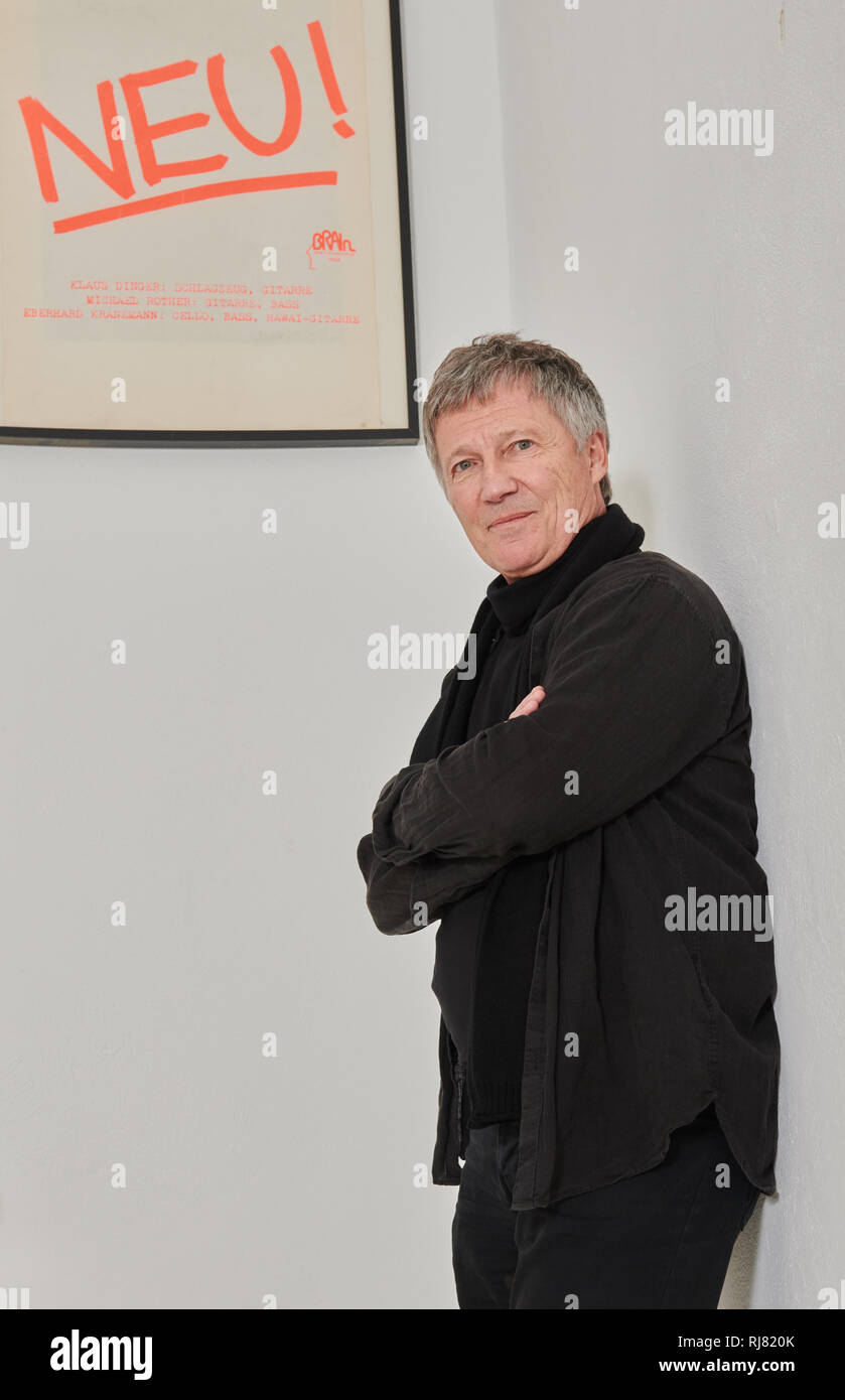Berlin, Allemagne. 17 Jan, 2019. Le musicien Michael Rother s'appuie contre le mur de sa maison de disques Dominique Bureau et regarde l'affiche de son groupe Neu ! (1971-1975). Son nouvel album 'Solo' sera publié le 22.02.2019. Credit : Annette Riedl/dpa/Alamy Live News Banque D'Images