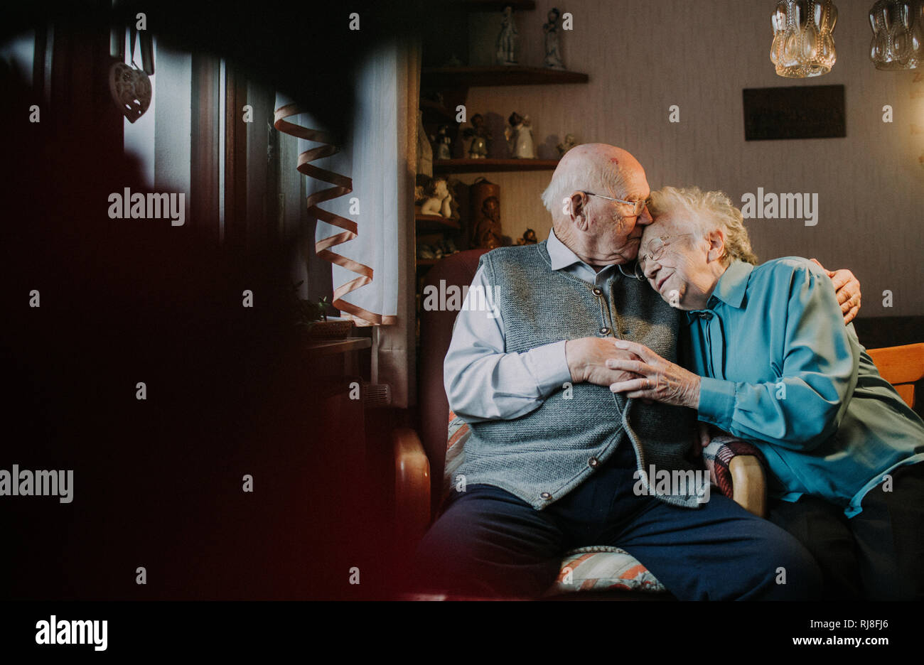 Seniorenpaar kuschelnd im Wohnzimmer Banque D'Images