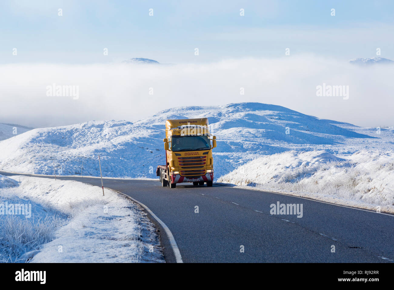 Phil Reid camion Scania voyageant le long de la route A82 sur journée d'hiver avec la neige autour et du brouillard givrant à Rannoch Moor, Highlands, Scotland en hiver Banque D'Images