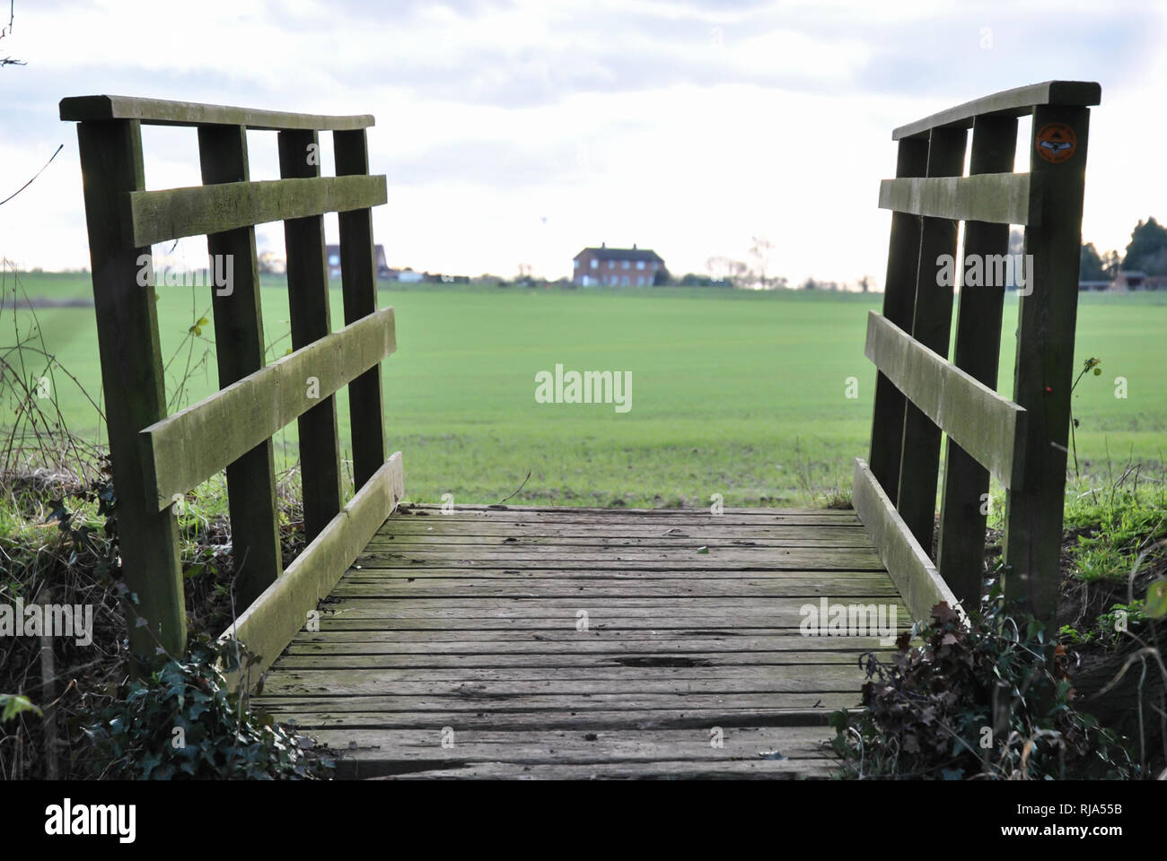 Un pont sur un ruisseau sur le Shropshire façon montrant un champ vert en arrière-plan avec maison sur une colline. Banque D'Images