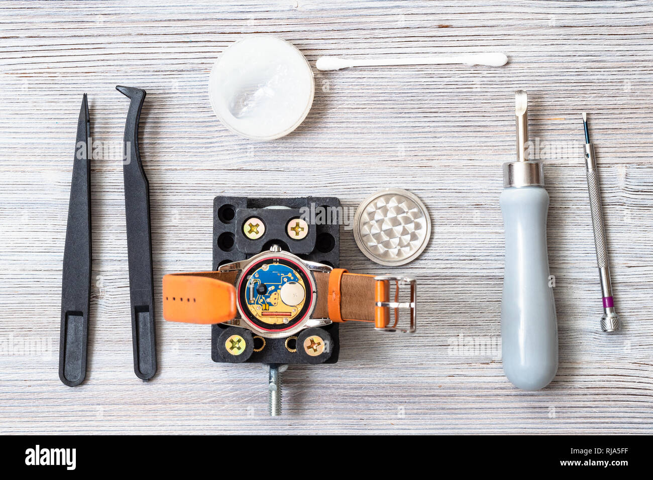 Regardez l'atelier de réparateur d'équipement de remplacement de batterie en montre-bracelet quartz sur table en bois Banque D'Images