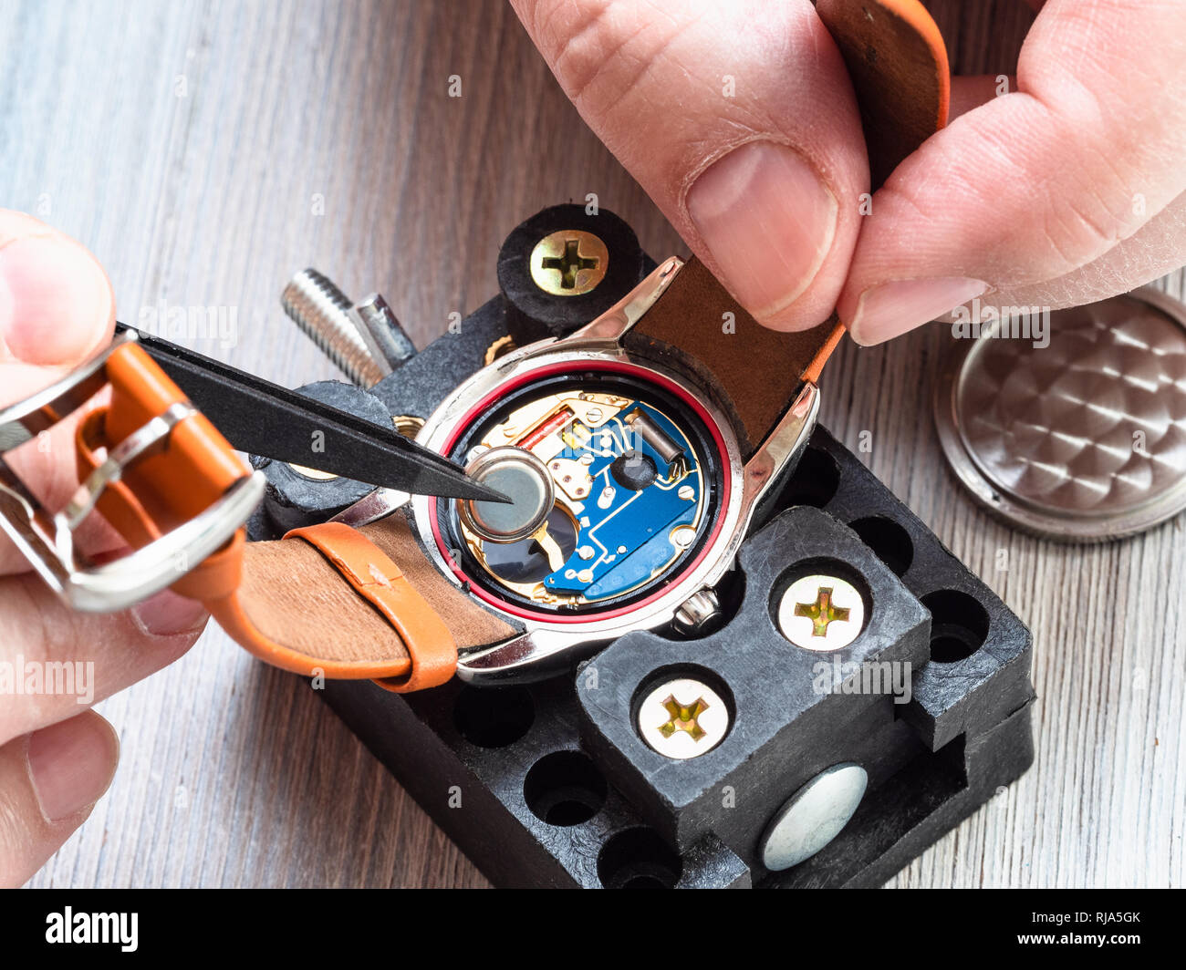Watch - atelier de réparateur réparation horloger montre-bracelet à quartz avec des pinces en plastique sur la table en bois close up Banque D'Images