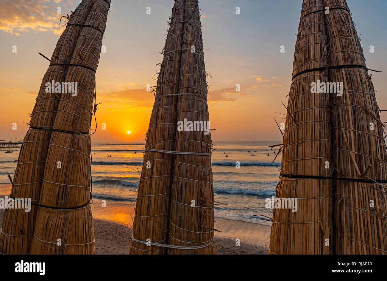 Roseau totora traditionnels bateaux le long de la plage de Huanchaco au coucher du soleil près de Trujillo, Pérou. Banque D'Images