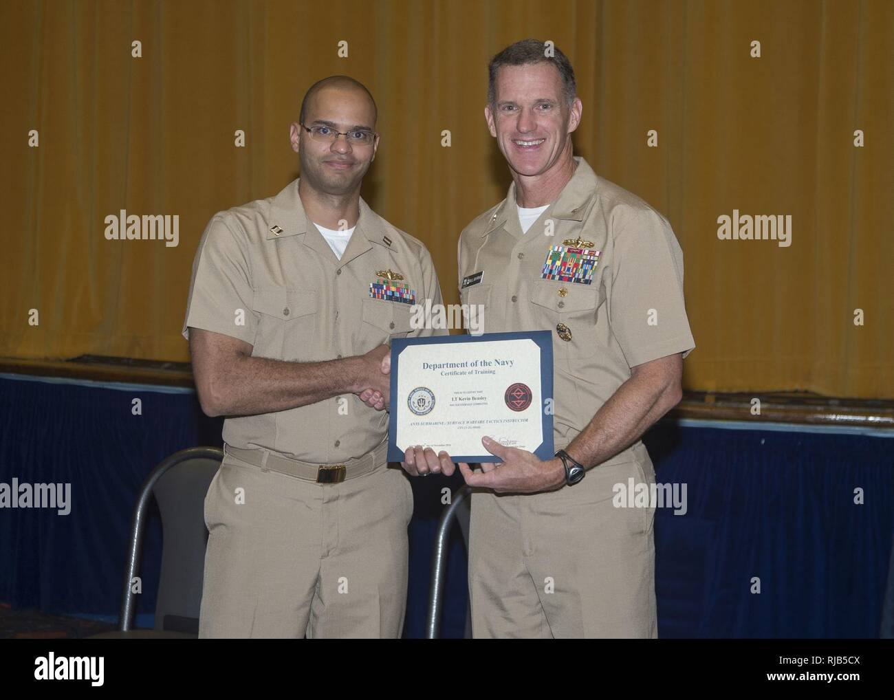 SAN DIEGO (nov. 4, 2016) Le lieutenant Kevin Beasley est félicité par Adm arrière. William Byrne, commandant du groupe aéronaval, 11, au cours d'une cérémonie de remise de diplômes et de Combat Naval Surface Mine Centre de développement (SMWDC) 17 nouveaux instructeurs tactiques de guerre de la base navale de San Diego. Beasley a été le 100e officier de guerre de surface d'obtenir leur diplôme d'SMWDC 90 jours intensifs au cours du WTI. La cérémonie est Byrne key note le président a dit, 'Vous êtes maintenant les enseignants, les entraîneurs et les mentors pour la flotte -- bien enseigner, coach bien et bien diriger." s'apparente à l'École d'armes de chasse de la Marine (TOP GUN) pour le meilleur de la Marine aviators, Banque D'Images