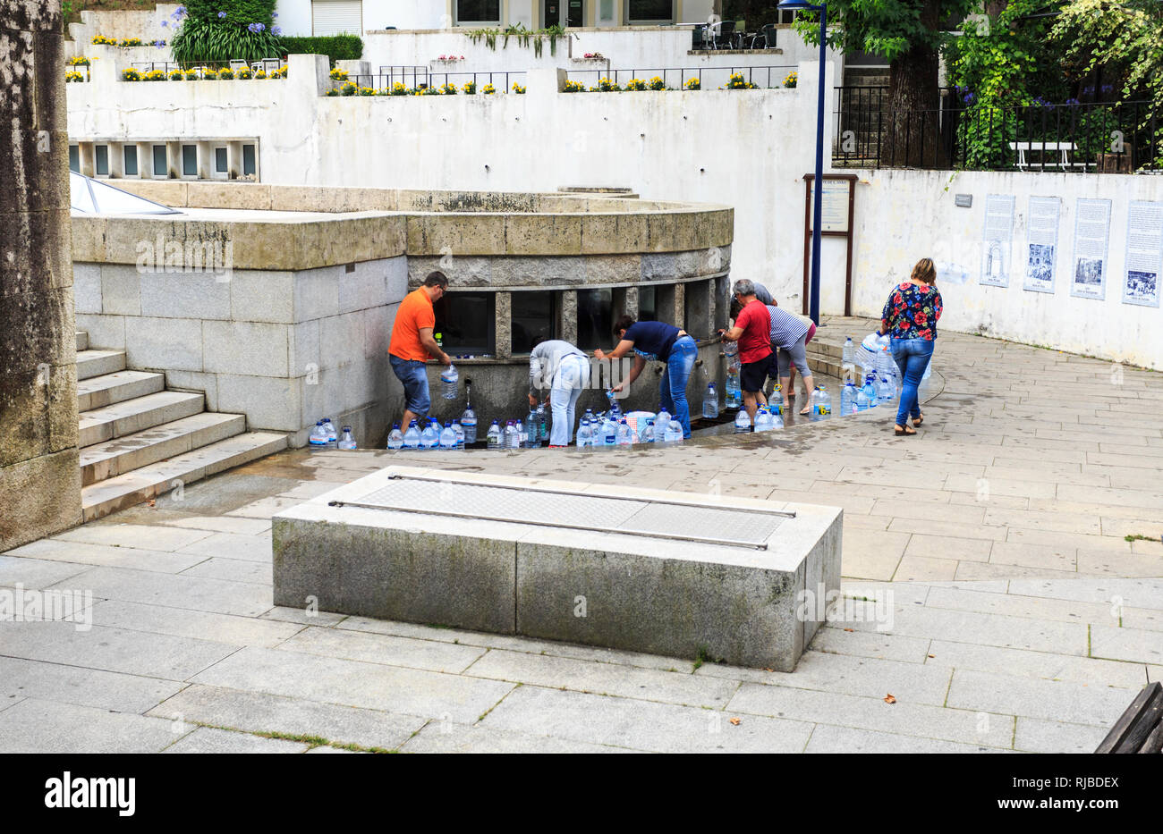 Les personnes qui reçoivent la célèbre Agua de Luso Luso (eau minérale) à partir de la fourniture gratuite fontaine de St John dans le centre de la ville de Luso, Portugal Banque D'Images