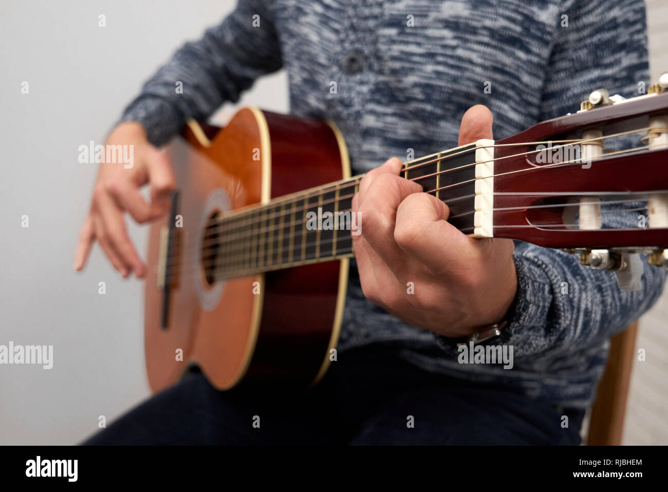 Mains de man holding instrument et jouer la guitare acoustique. Close up de chaînes. Musicien professionnel d'effectuer. Concept d'instruments de musique, de spectacles et de la musique. Banque D'Images