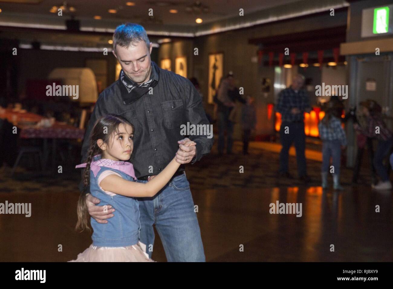 Les membres du service et leurs filles fréquentent les bottes 'n Belles Daddy-Daughter Danse à Iwakuni Marine Corps Air Station, Japon, le 13 janvier 2018. Les pères et les filles dansaient, pris des photos, des jeux et a gagné des concours de tirage comme ils ont partagé la nuit et créé des souvenirs ensemble. Banque D'Images