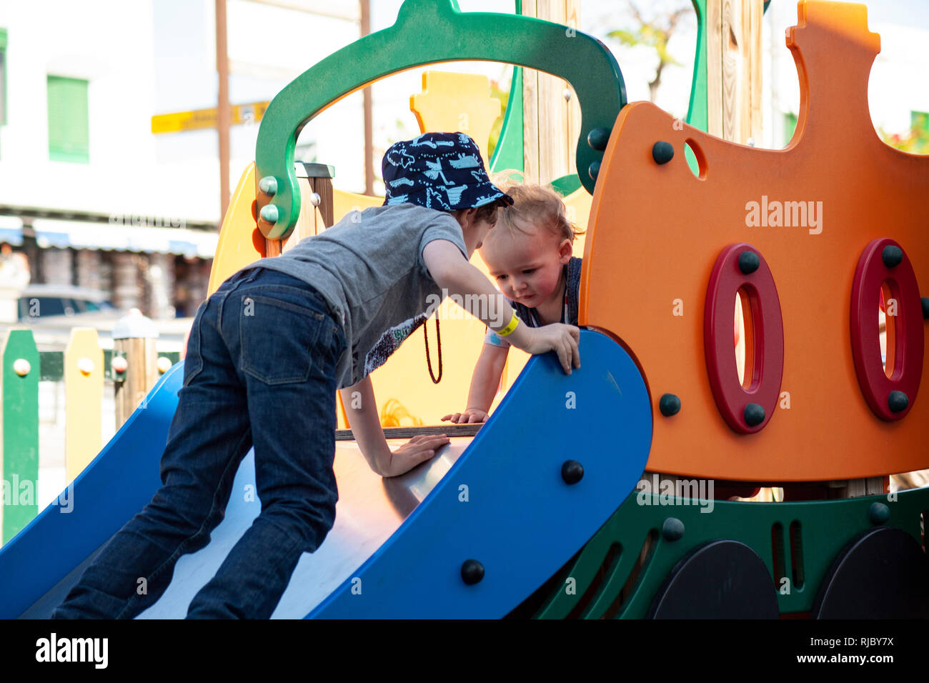 Enfants/frères jouent ensemble en slide at play park Banque D'Images