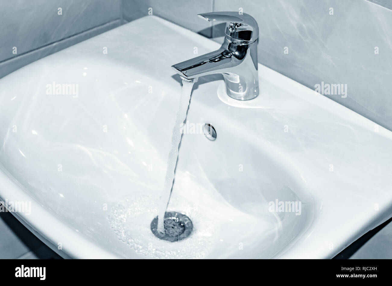 Évier et robinet avec l'eau qui coule dans la salle de bains Photo Stock -  Alamy