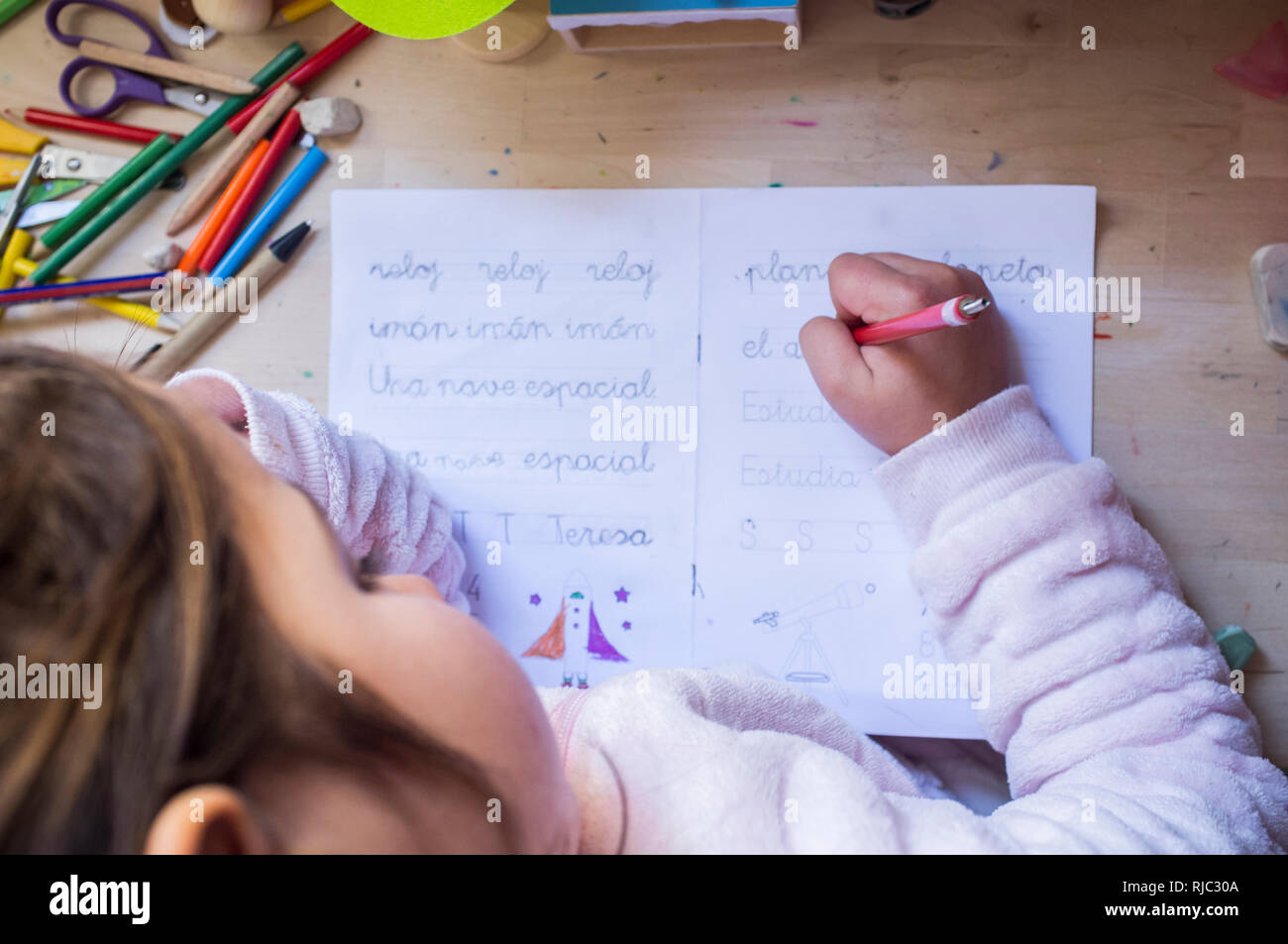 Enfant de 6 ans girl doing homework écrit dans sa chambre. Les enfants à apprendre à écrire concept Banque D'Images